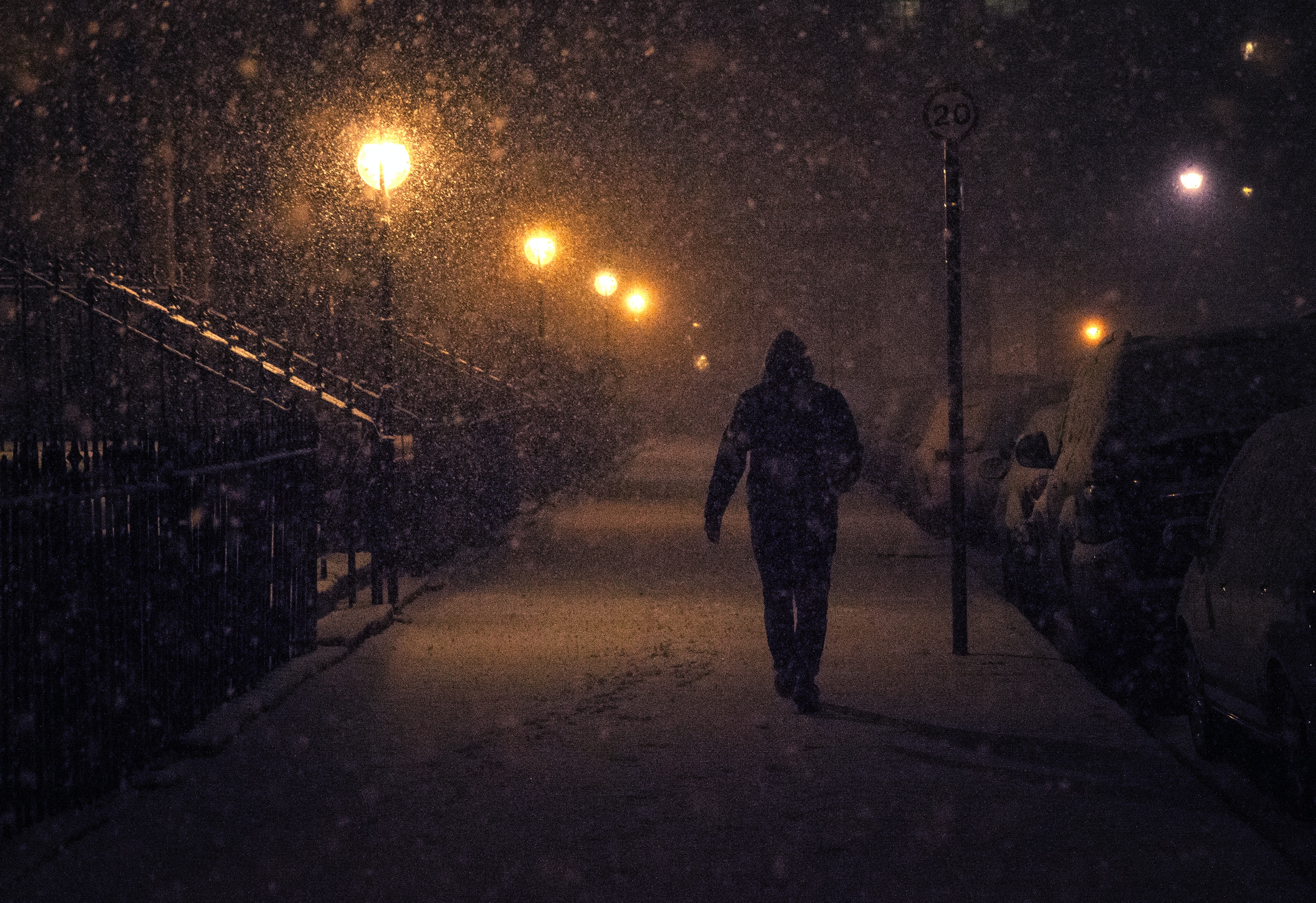 Person walking outside in the snow, in the dark, to represent seasonal affective disorder (SAD).