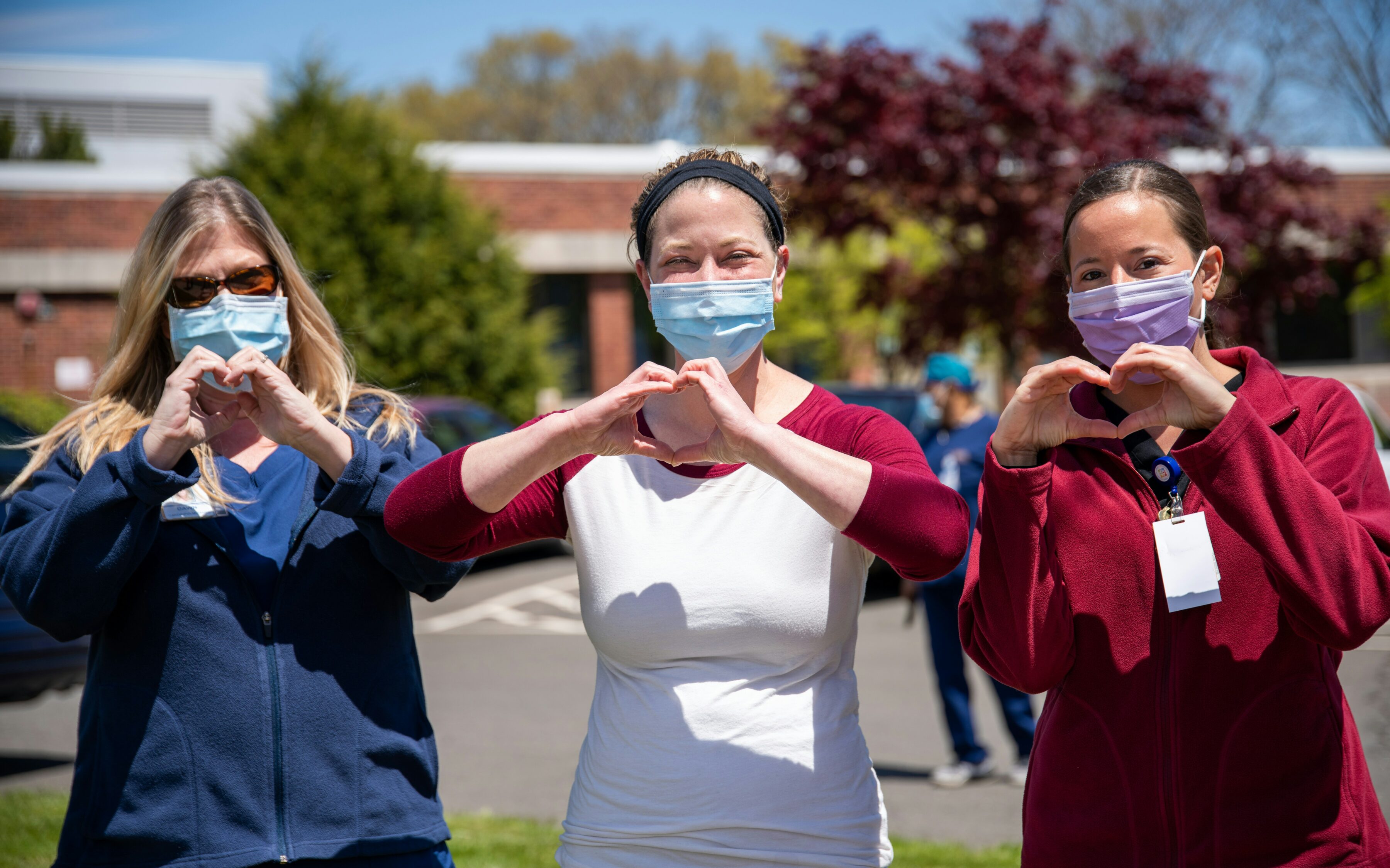 A picture showing different types of nurses making heart signs with their hands.
